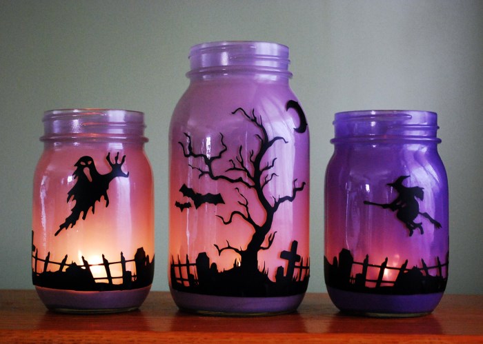 Colored glass jars with burning candles inside
