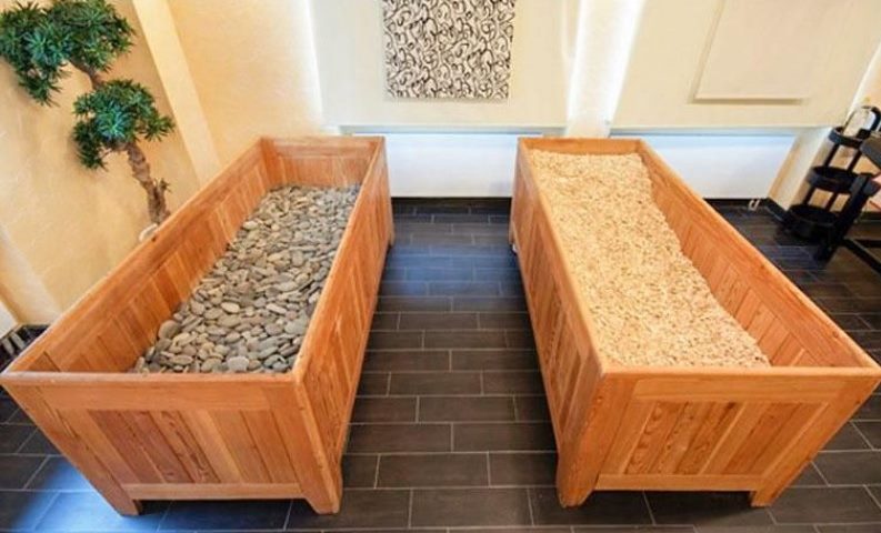 Scatole di legno con ciottoli e segatura in una sauna giapponese