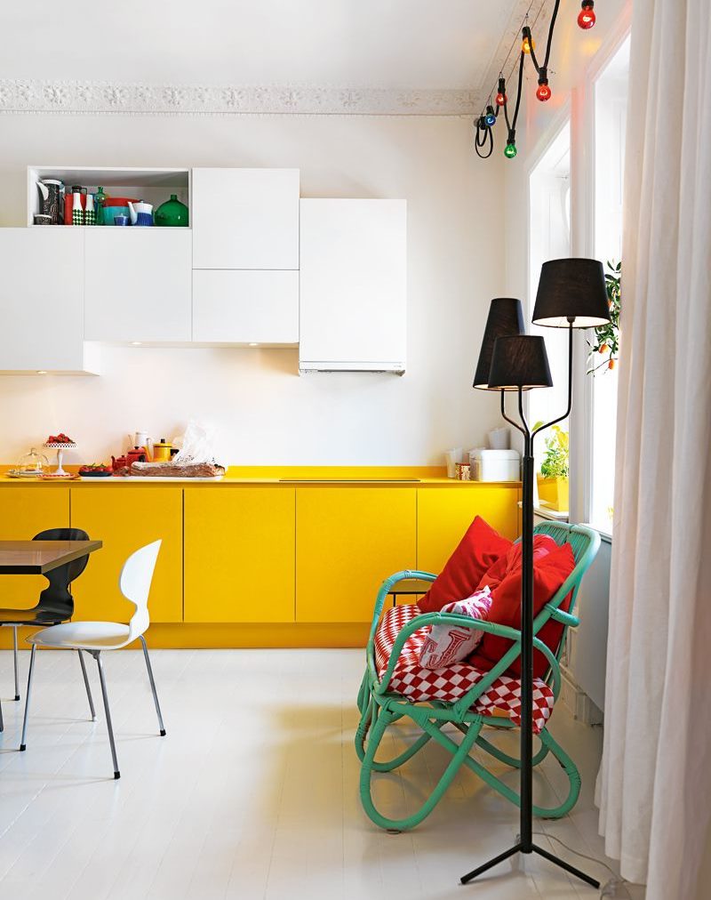 Armoires de cuisine jaunes contre un mur blanc