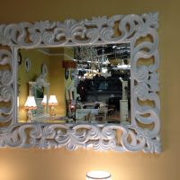 Cornice bianca intagliata sullo specchio