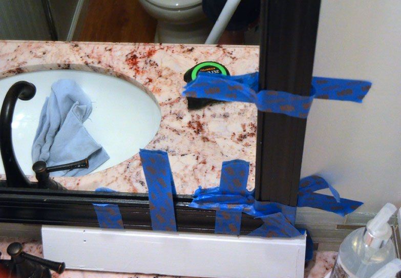 Fissaggio delle lamelle della cornice dello specchio con nastro adesivo