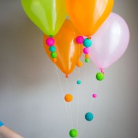 Ballons à l'hélium avec des pompons en papier
