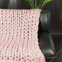 Cape tricotée sur un canapé en cuir
