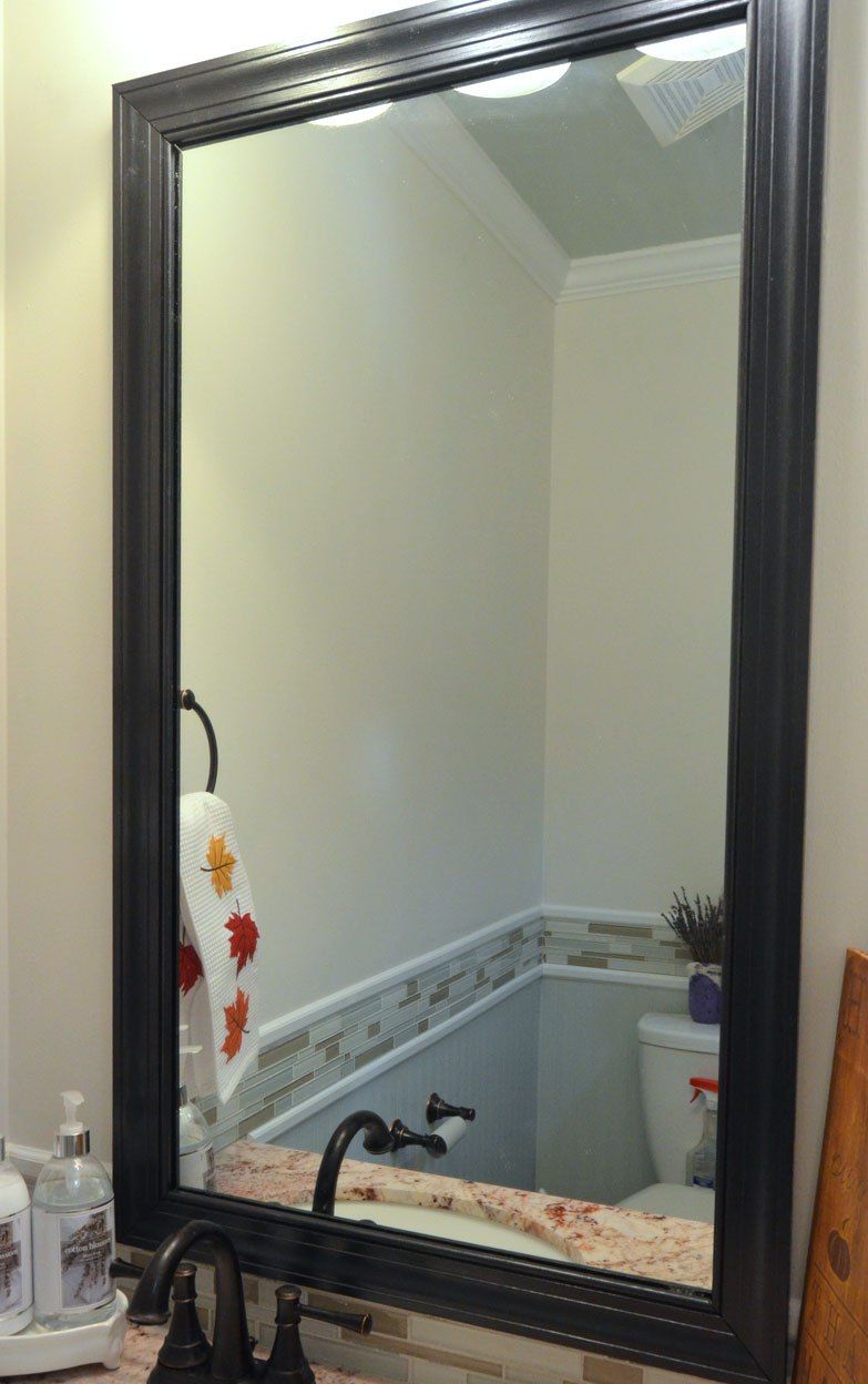 Cornice nera del battiscopa sullo specchio del bagno