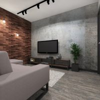 Télévision noire dans le salon avec mur de briques
