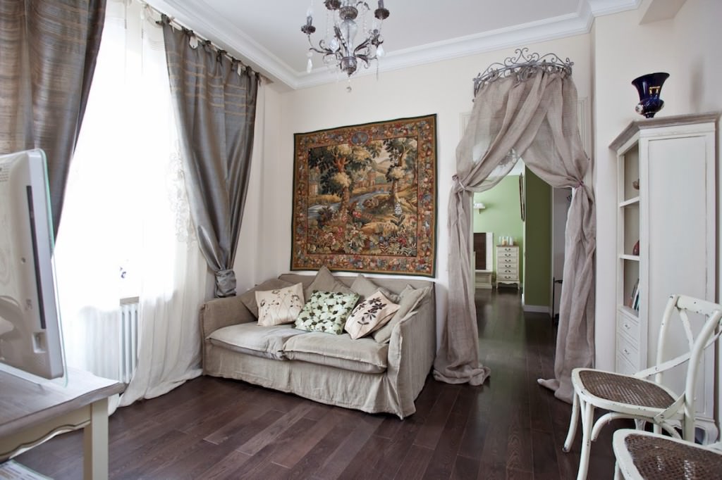 Provence stílusú nappali belső része szürke kanapéval.