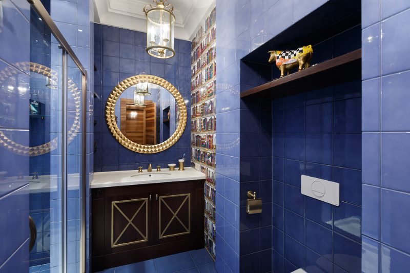 Intérieur de la salle de bain avec carreaux bleus au mur.