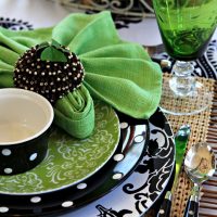Tovaglioli verdi su piatti con ornamento nero