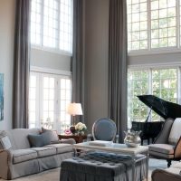 Melnas klavieres viesistabā ar lieliem logiem